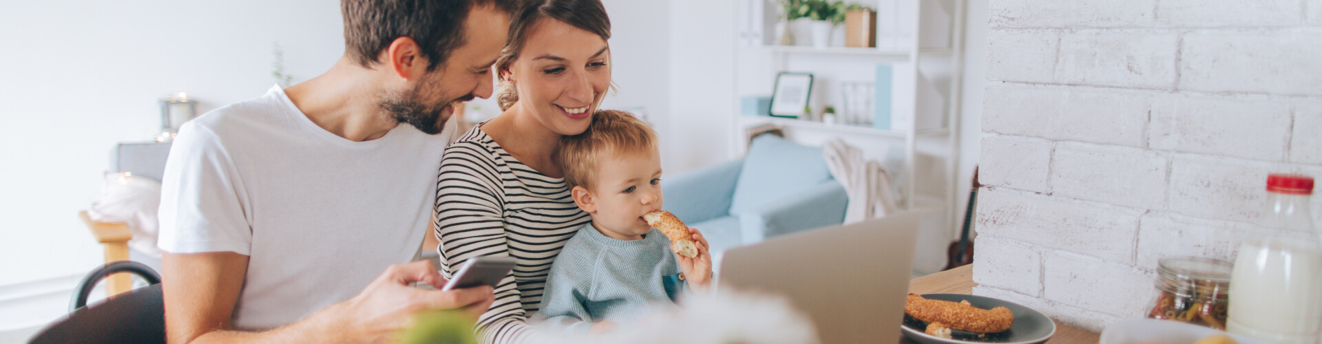 "family looking at a laptop and smiling"